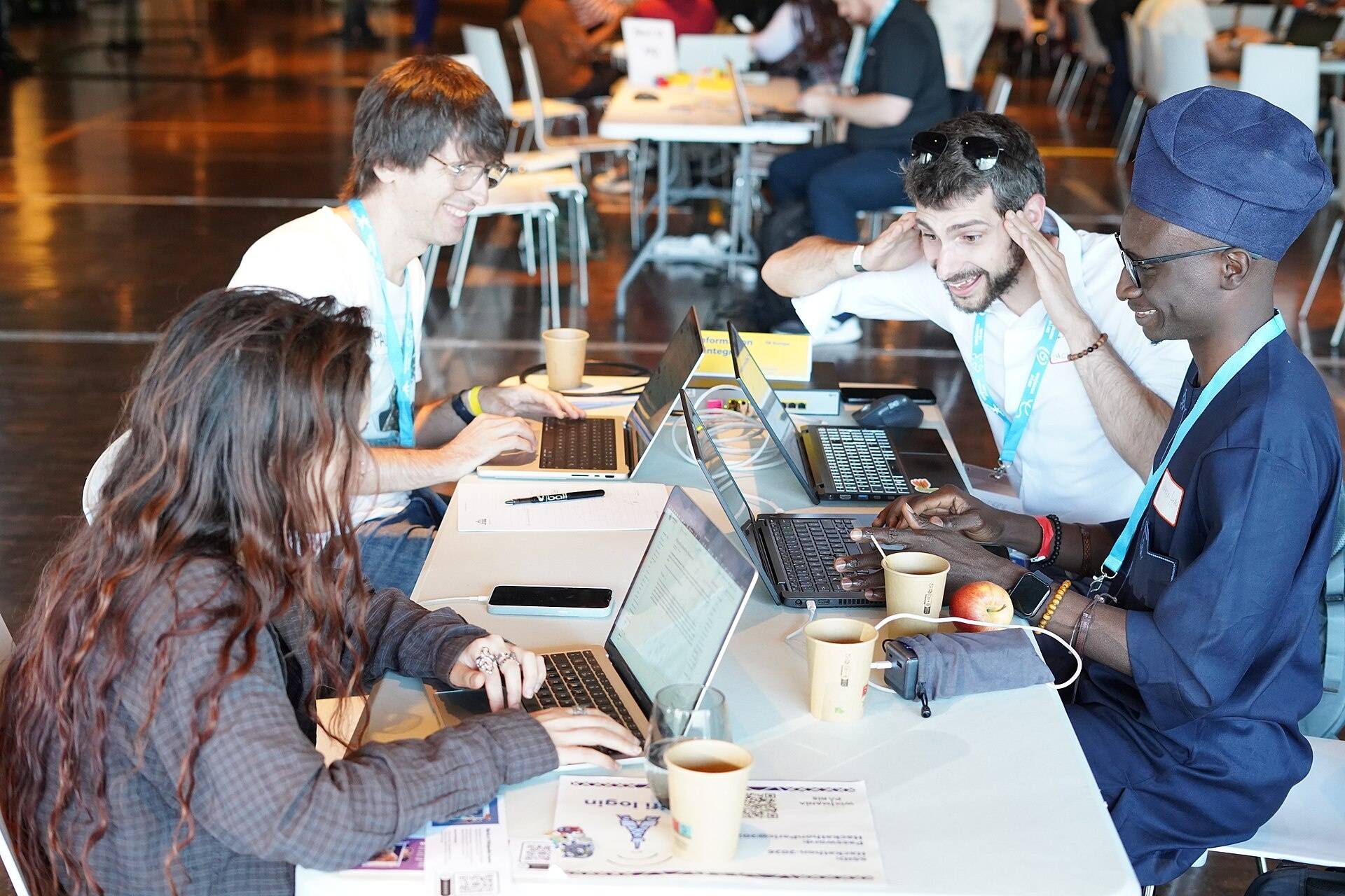 Une équipe rit autour de ses ordinateurs à la fin d'une session.